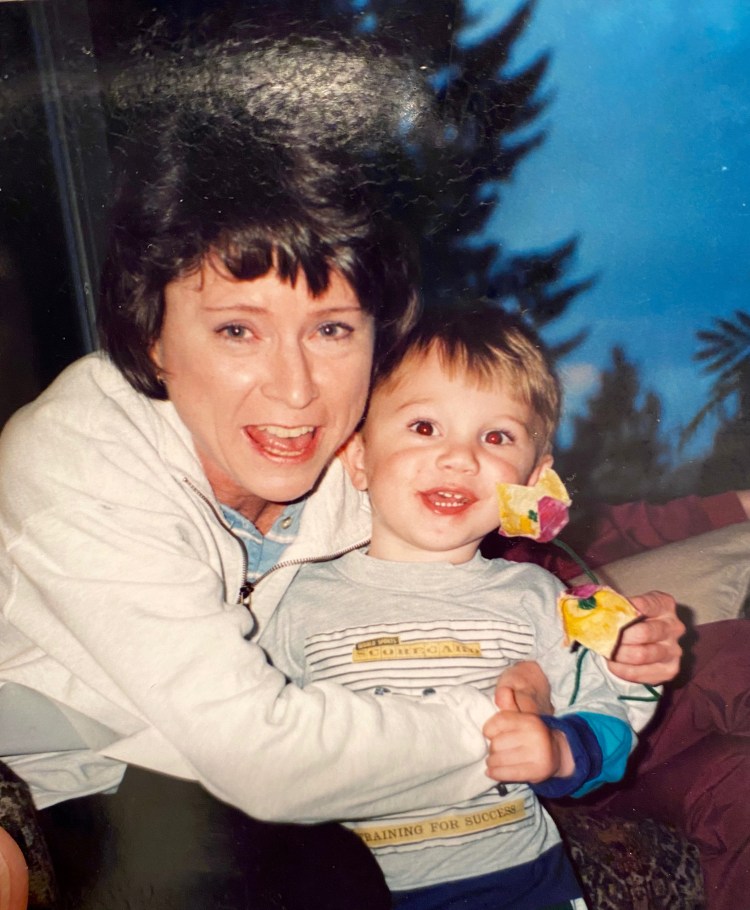 Kathy holding Riley and the flowers he made for her